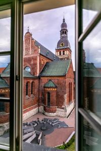 Blick auf ein großes Backsteingebäude aus einem Fenster in der Unterkunft Ars Vivendi Rezidence in Riga