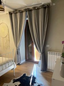 1 dormitorio con cortinas, 1 cama y ventana en Il Borghetto, en Mentana