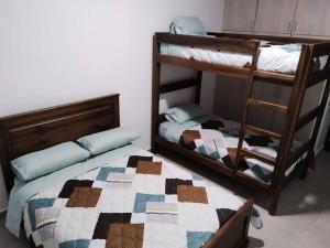 een slaapkamer met 2 stapelbedden en een quilt bij Arenal's Beach Home in Playas