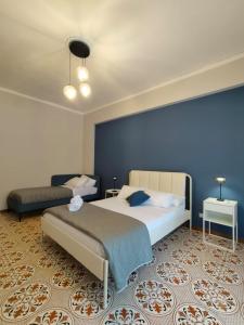 una camera da letto con un letto e una parete blu di Luma casa Vacanze Cefalù a Cefalù