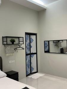 a room with two mirrors on the wall and a bed at Anjung Barakah Chalet in Kuala Terengganu