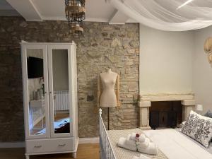 1 dormitorio con pared de piedra y maniquí en Il Borghetto, en Mentana