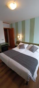 a large bed in a hotel room with a large bed sidx sidx at Albergo Ristorante Cacciatori in Auronzo di Cadore