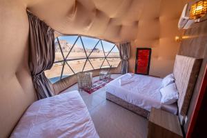 a bedroom with two beds and a large window at Sultan Al_ wadi rum in Wadi Rum