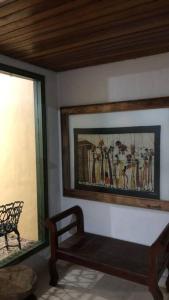 ein Zimmer mit einer Bank und einem Gemälde an der Wand in der Unterkunft Hospedagem em meio a natureza! in Águas da Prata