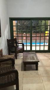 dwie ławki i stół w pokoju z oknami w obiekcie Hospedagem em meio a natureza! w mieście Águas da Prata