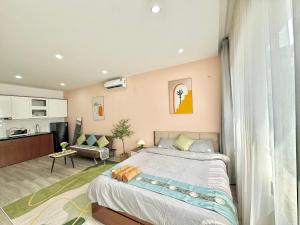 a bedroom with a large bed and a kitchen at The Little Home - Cù Chính Lan - Modern & Comfy Apartment in Hanoi