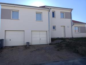 ein weißes Haus mit vier Garagentüren darauf in der Unterkunft Aux pieds de la colline de Mousson in Pont-à-Mousson