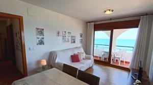 een woonkamer met een witte bank en een balkon bij Primera Línea de Playa, Ada Benedicto XIII, Aire acondicionado, WiFi, Parking in Peñíscola +56 foto's