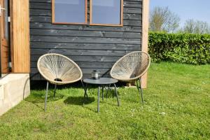 dos sillas y una mesa frente a una casa en Tinyhouse Giethoorn en Giethoorn