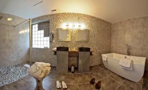 uma casa de banho com uma banheira e um lavatório em LOGIS Auberge DE LA TRUFFE em Sorges