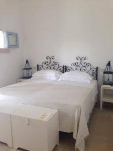 オートラントにあるMasseria Montelauroのベッドルーム1室(白いシーツが備わるベッド2台付)