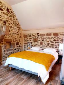 1 dormitorio con 1 cama en una pared de piedra en Le Loft du Clos Giot en Saint-Vaast-la-Hougue