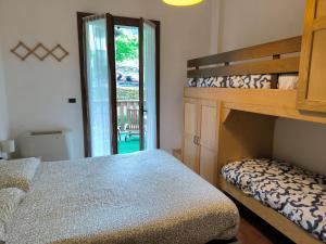 1 dormitorio con litera junto a una puerta en Bilocale Gran Chalet Montecreto en Montecreto