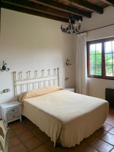 Un dormitorio con una gran cama blanca y una ventana en Posada El Jardin de Angela, en Santander