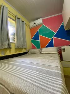 a bed in a room with a colorful wall at Hostel Sol da Barra in Salvador
