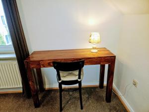 einen Schreibtisch mit einem Stuhl und einer Lampe in der Unterkunft Apartment Jackie 2 in Bielefeld