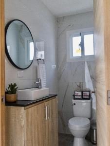 a bathroom with a sink and a mirror and a toilet at Villa Sian in Punta Cana