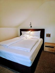 una camera da letto con un grande letto con lenzuola e cuscini bianchi di Apartment Jackie 2 a Bielefeld