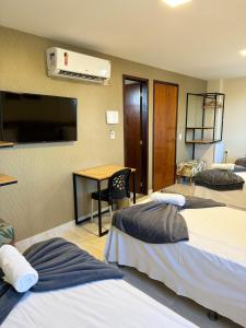 Habitación de hotel con 2 camas y TV de pantalla plana. en Pousada Elo Inn en Recife