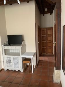 a room with a desk with a tv and a door at Posada El Jardin de Angela in Santander
