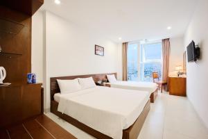 Postel nebo postele na pokoji v ubytování Golden Light Da Nang Hotel