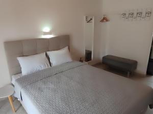 a bedroom with a large bed with a gray comforter at The Port in Porto Koufo