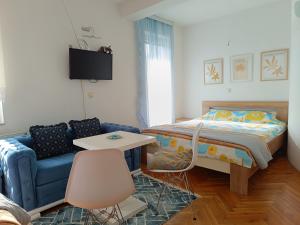 a bedroom with a bed and a blue couch at Vila Sentić in Vranje