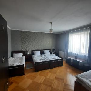 カズベギにあるGIO-NIKAのウッドフロアのベッドルーム1室(ベッド2台、窓付)が備わります。