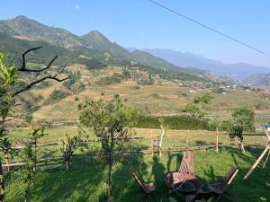 a view of a field with mountains in the background at Pavi garden in Sa Pa