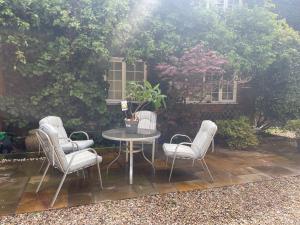 a patio with a table and four chairs at Da Vinci Guest House & Guest Parking in Crawley