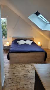 - une chambre avec un lit doté d'une couette bleue et d'une fenêtre dans l'établissement Appartement cosi au cœur de la Venise Normande, à Pont-Audemer