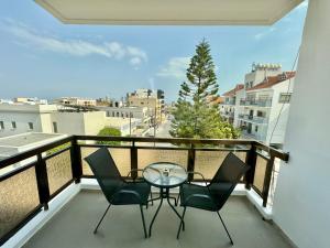 a balcony with a glass table and chairs on a balcony at Elegant penthouse in Limassol in Limassol
