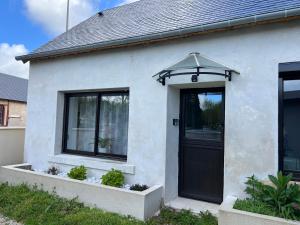 a white house with a black door and windows at Les Haltes de la Rive Gauche in Sury-près-Léré