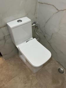 a white toilet in the corner of a bathroom at Hotel Kashyaam Inn in Varanasi