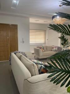 Corner of Paradise 4 bedrooms with private pool Yasmine Hammamet في الحمامات: غرفة معيشة بها كنبتين بيضاء ومصنع