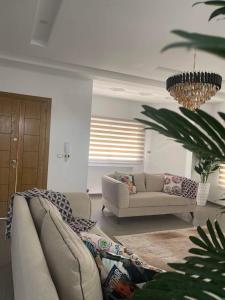 a living room with a couch and a chandelier at Corner of Paradise 4 bedrooms with private pool Yasmine Hammamet in Hammamet