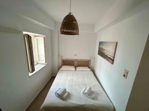 a small bedroom with a bed and a window at Giasemi Syros in Ermoupoli