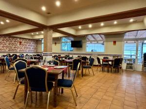 un restaurante con mesas y sillas y TV de pantalla plana en HOSTAL-RESTAURANTE POSADA DEL DUQUE, en Villalbilla de Burgos