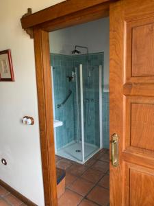 baño con ducha y puerta de cristal en Posada El Jardin de Angela, en Santander