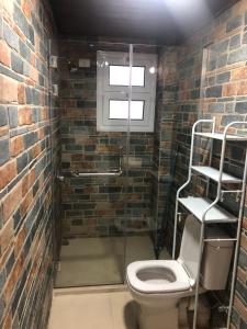 a bathroom with a toilet and a brick wall at Dahab Relax Studio 2 in Dahab