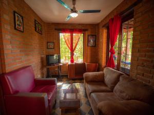 uma sala de estar com sofás e uma parede de tijolos em 2 bedroom apartment in lush garden, 3 blocks from beach and center of San Juan em San Juan del Sur