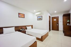 Postel nebo postele na pokoji v ubytování Golden Light Da Nang Hotel