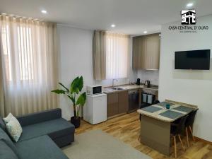 a living room with a couch and a kitchen at Casa Central D'ouro in Tabuaço