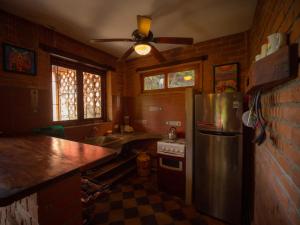 a kitchen with a stainless steel refrigerator and a sink at 2 bedroom apartment in lush garden, 3 blocks from beach and center of San Juan in San Juan del Sur