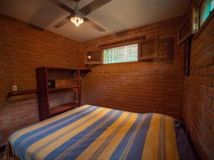 um quarto com uma cama numa parede de tijolos em 2 bedroom apartment in lush garden, 3 blocks from beach and center of San Juan em San Juan del Sur