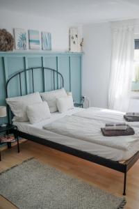 uma cama num quarto com uma parede azul em BUCHLINDENWEG - Zimmer & Ferienwohnung em Breitscheid