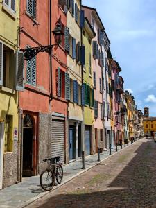 uma bicicleta estacionada numa rua ao lado de edifícios em Jolie Maison au coeur de Parma Parking privé gratuit em Parma