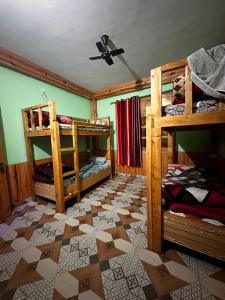 een kamer met 2 stapelbedden en een plafond bij Ohana cafe & homestay in Kasol