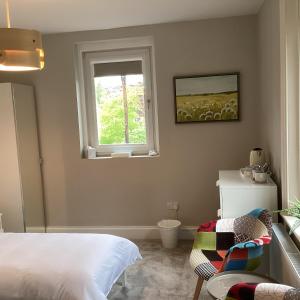 1 dormitorio con cama y ventana en Belford House Self Check-in Rooms en Haltwhistle